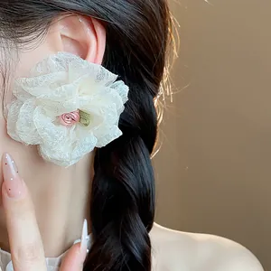 Close-up of elegant white chiffon flower earrings worn by an Asian fashion model