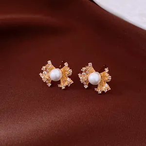 Detailed view of vintage fan-shaped earrings with gold finish, pearls, and zircons
