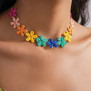 Close-up of a colorful handcrafted raffia flower choker necklace worn by a model.