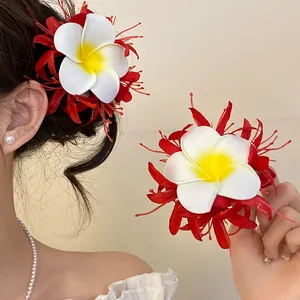 Vista dettagliata di un fermaglio per capelli bohémien con plumeria e fiori rossi su modella