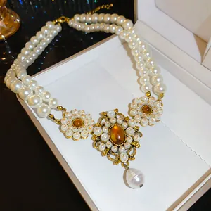 Detail of vintage French palace style double-strand pearl necklace with amber gem pendant