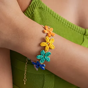 Detailed view of a colorful raffia flower bracelet worn on a wrist for summer vacation style