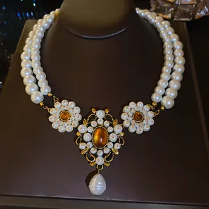 Close-up of vintage French court style double-strand pearl necklace with amber pendant