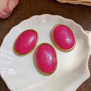 Elegant pink resin oval stud earrings jewelry set with gold rims on shell plate