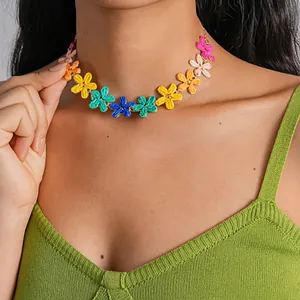 Close-up detail showing a vibrant colorful raffia flower necklace on the model's neck