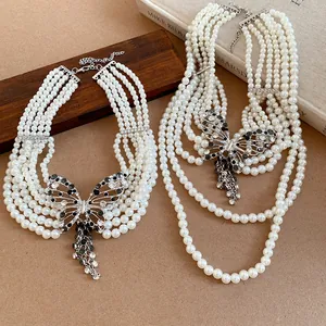 Detailansicht der mehrlagigen Vintage-Perlenhalsketten mit Strass-Schmetterlingsanhänger