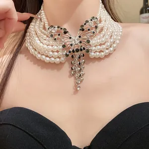 Detailansicht eines eleganten mehrlagigen Perlen-Chokers mit Strass-Schmetterling.