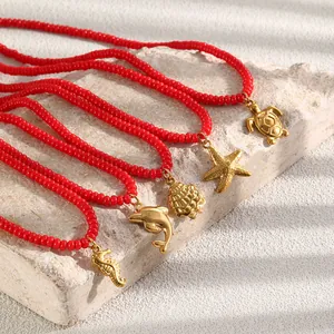 Rode glaskralen ketting met 18K gouden oceaanhangers zoals zeester en schildpad.