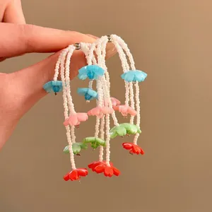 Close-up of colorful floral beaded drop earrings with vibrant multi-colored flower pendants