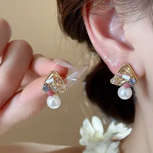 Detail shot of French vintage 18k gold plated earrings with pearls and colorful glass.