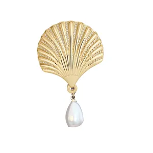 Elegant golden shell hair clip with micro-pave stones and a dangling teardrop pearl.