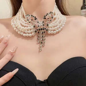 Detailansicht eines mehrreihigen Perlenchokers mit funkelndem Schmetterlingsanhänger.