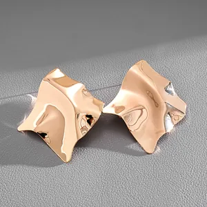 Detailed view of gold irregular geometric stud earrings with high-shine metallic finish