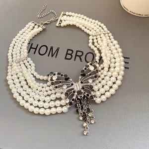 Detailansicht eines mehrreihigen Perlen-Chokers mit funkelndem Strass-Schmetterling