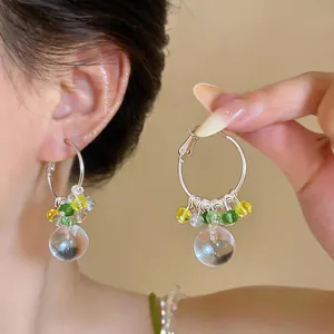 Primo piano di orecchini a cerchio in argento stile vacanza con perline colorate