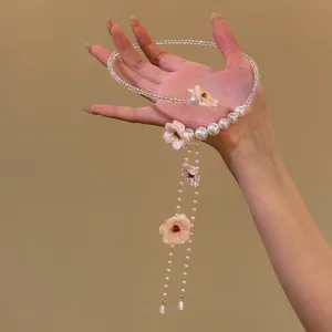 Détail du collier élégant à fleurs roses et glands avec perles et cristaux