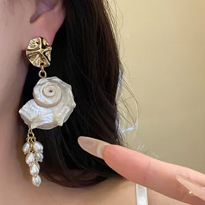 Detailed view of vintage French style shell and pearl tassel earrings with gold accents