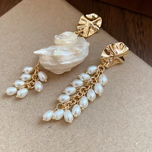 Detailed close-up of French vintage gold pearl tassel earrings with seashell accent