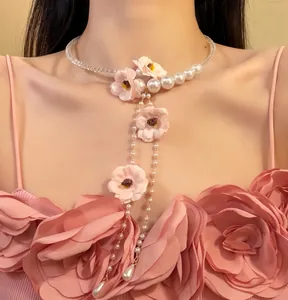 Gros plan d'un collier élégant en fleurs roses avec glands en perles et perles de cristal.