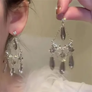 Close-up detail of grey water-drop tassel earrings with shimmering crystals