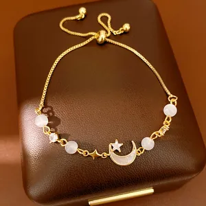 Close-up of elegant gold moon and star bracelet with cat's eye beads on jewelry box