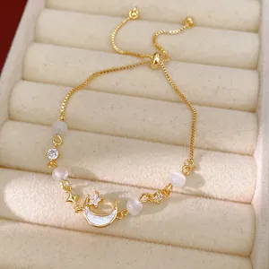 Detailed view of gold moon bracelet featuring cat's eye stones and sparkling zircons