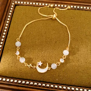 Detail of gold moon and cat's eye stone bracelet with adjustable slider clasp