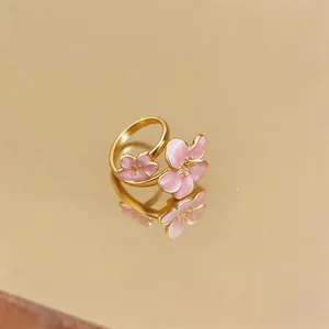 Dettaglio di un anello a fiore di ciliegio in smalto rosa con fascia regolabile placcata oro