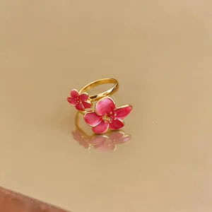 Vista dettagliata dell'anello a fiori in smalto rosa con elegante finitura dorata