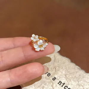 Vista dettagliata di un elegante anello d'oro con delicate decorazioni floreali in smalto