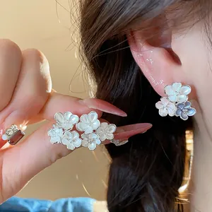 Detailed close-up of elegant dripping oil flower stud earrings shown on ear for a delicate look