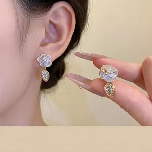 Elegant white enamel rose drop earrings with shimmering rhinestones for stylish women.
