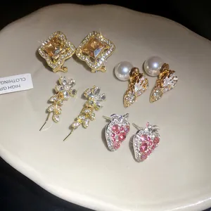 Detailed macro shot of diverse sparkling strawberry and floral stud earrings set