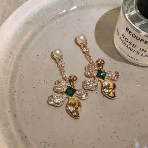 Elegant vintage style gold floral drop earrings featuring green gems and pearl accents