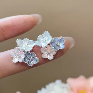 Close-up of elegant flower stud earrings with colorful enamel dripping oil finish
