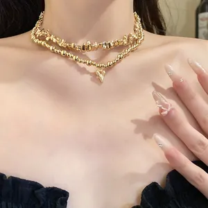 Dettaglio di una collana girocollo vintage a due strati dorata con pendente a cuore