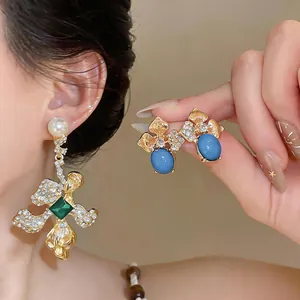 Detailed macro view of vintage gold flower earrings with sparkling rhinestones and blue stones.