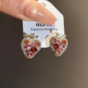 Macro view of sparkling pink rhinestone strawberry stud earrings on a product card.