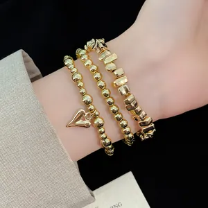 Dettaglio di un set di bracciali di perline dorate vintage con ciondolo a cuore