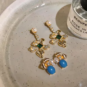Close-up macro view of vintage-style floral drop and stud earrings with gemstones