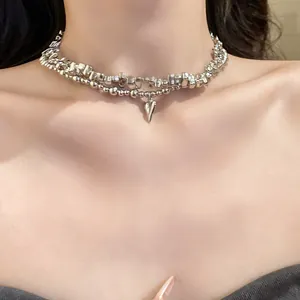 Vista dettagliata di una collana girocollo a due strati argentata con ciondolo a cuore minimalista