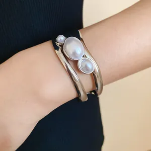 Close-up of vintage hollow silver cuff bracelet with three oval pearls