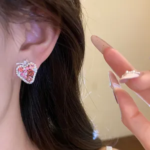 Detailed close-up showing a sparkling pink rhinestone strawberry stud earring on a model's ear