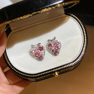 Close-up of sparkling pink rhinestone strawberry earrings in a jewelry box