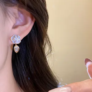 Close-up of elegant flower stud earring with shimmering pearl-like shell petals