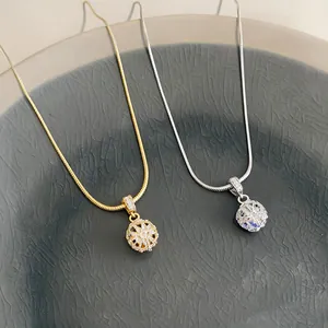 Detailansicht von eleganten Gold- und Silber-Zirkonia-Kugelanhängern auf einem grauen Teller
