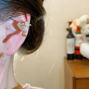 Detail of 18k gold plated zircon heart ear cuff with cross motif for non-pierced ears.