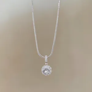 Makroaufnahme eines funkelnden runden Zirkon-Anhängers an einer eleganten Schlangenkette