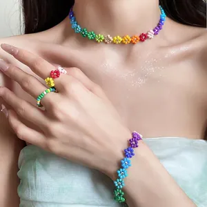 Handmade Bohemian rainbow seed bead flower necklace, bracelet and ring set on model