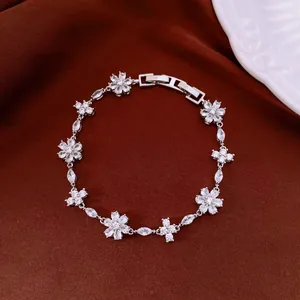 Detailed view of the sparkling zircon flower and cross motifs on a silver bracelet